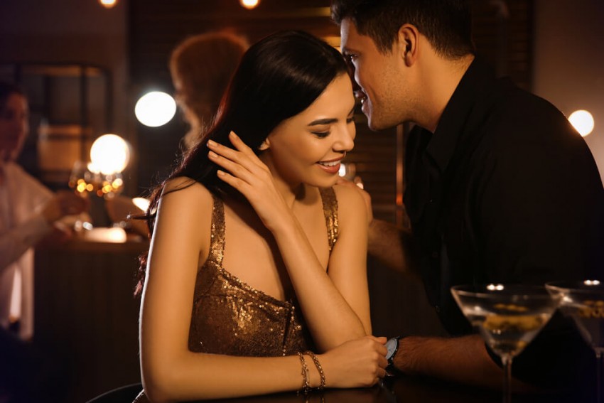 Ett attraktivt par upplever stark kemi och gnista i en bar, ett perfekt exempel på en lyckad seriös dejt fylld med flirt och passion.