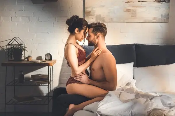 vackert sexigt par som omfamnar varandra i sängen