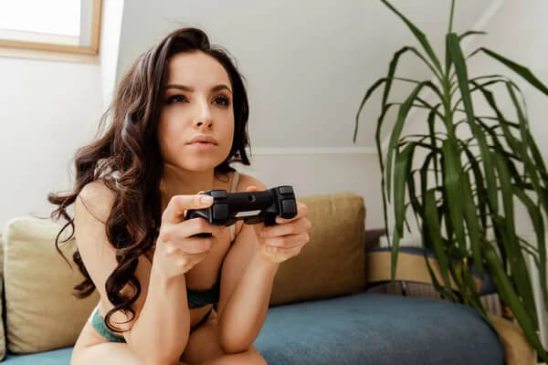 Sexig tjej med gamepad som spelar videospel